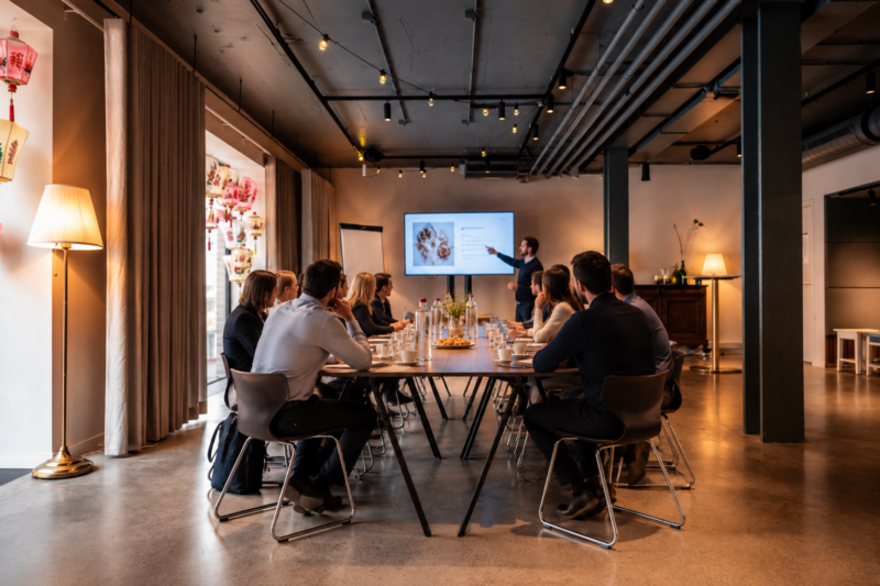 Vergadering met presentatie op een scherm in zaal Forastero van restaurant Octave