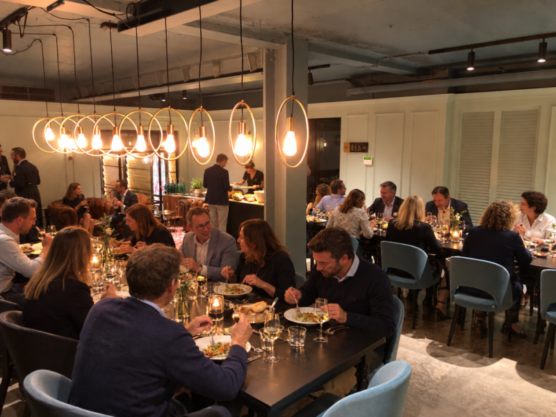 Groep gasten dineert onder warme hanglampen in zaal Porcelana van restaurant Octave