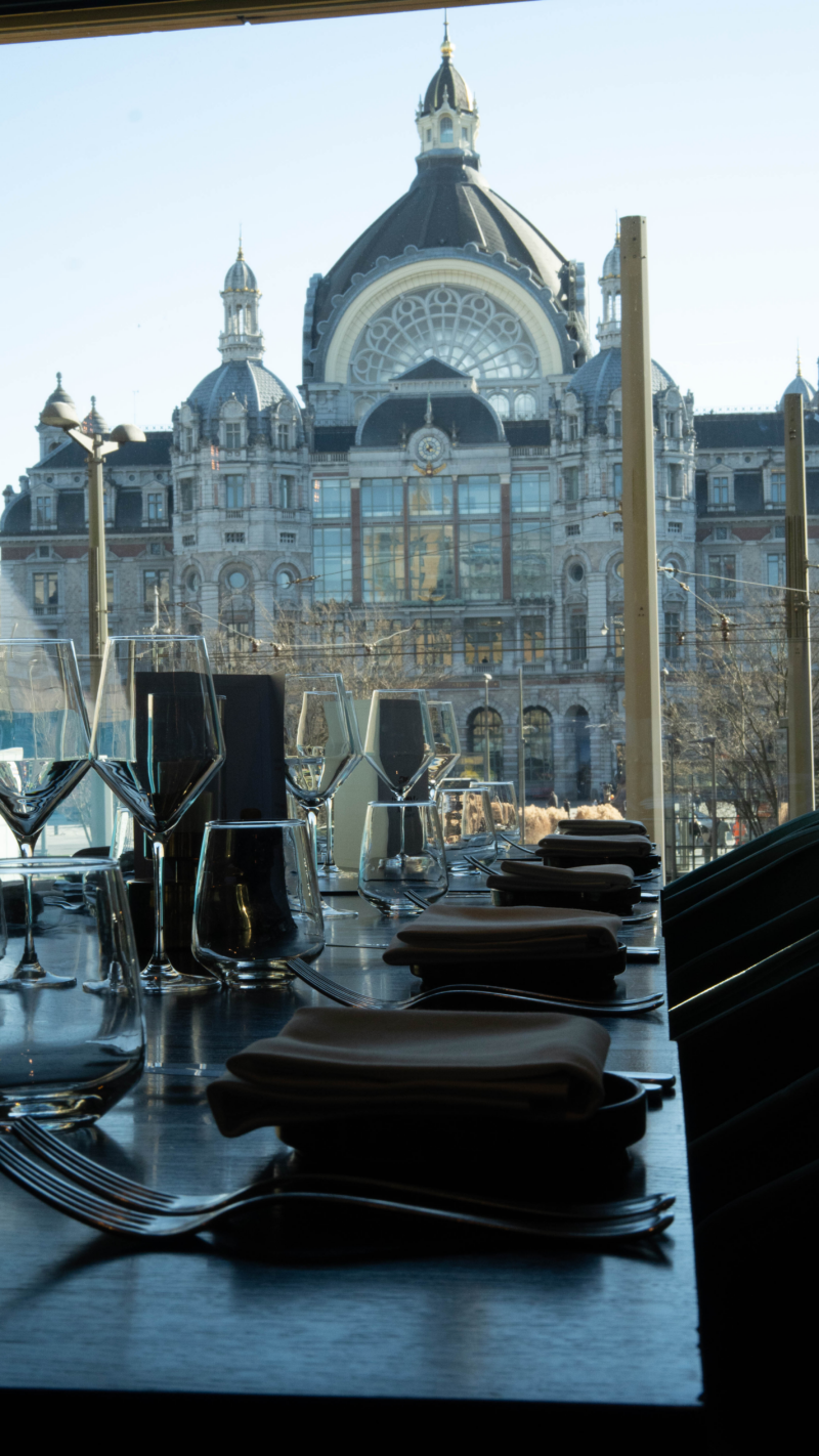 Gedekte tafel in restaurant Octave met zicht op station Antwerpen-Centraal